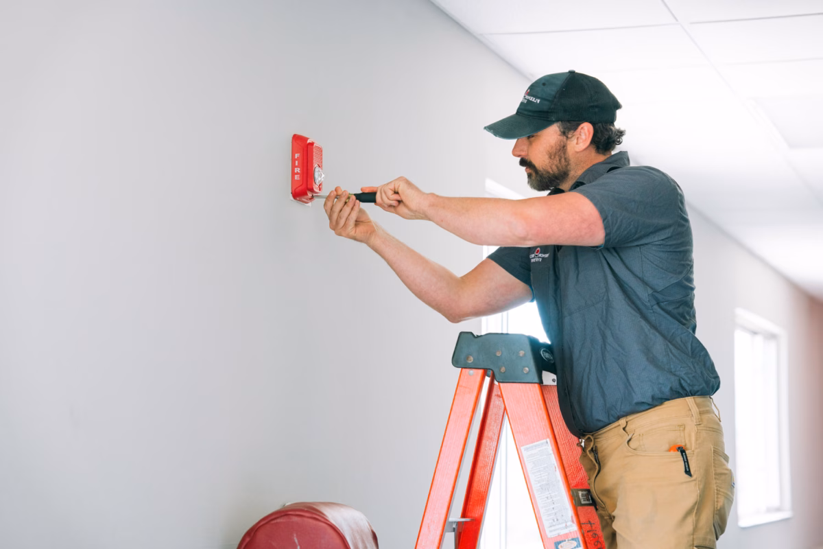 Fleenor worker installing fire alarm.